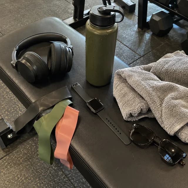 Acessórios de treino, garrafa e smartwatch na academia