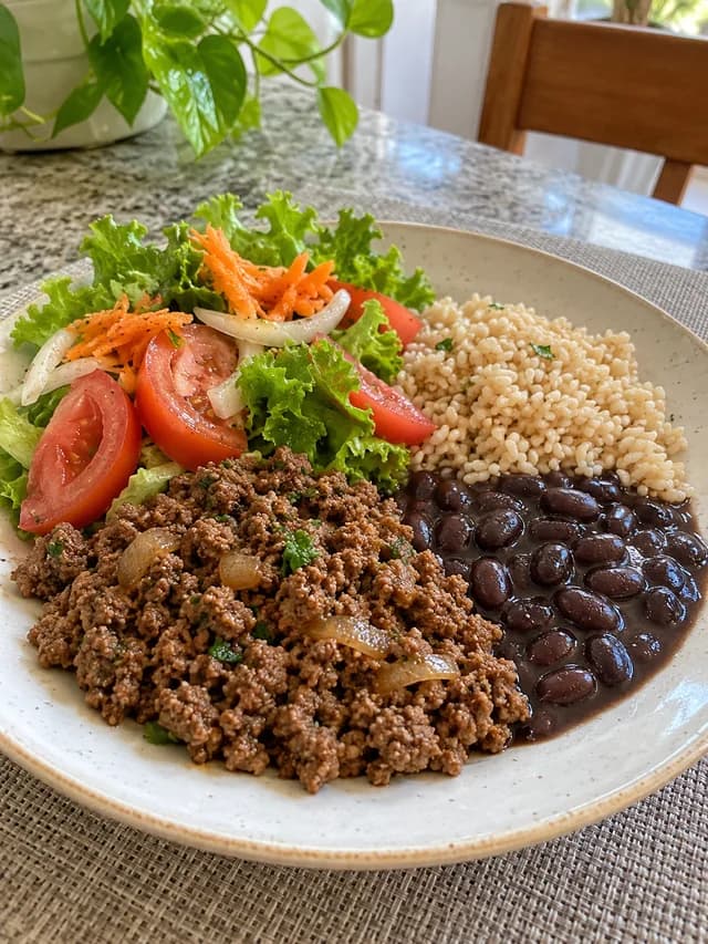 Prato com carne moída, arroz integral, feijão e salada